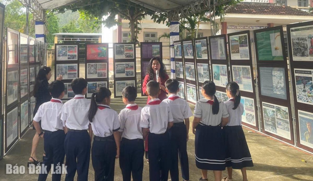 Các em học sinh được nghe thuyết minh về ý nghĩa của việc tái chế rác thải tại khu trưng bày.