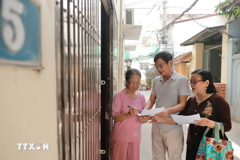 Đại diện các tổ dân phố đến từng nhà để lấy ý kiến nhân dân về phương án sắp xếp đơn vị hành chính hồi tháng 4/2025. Ảnh: TTXVN