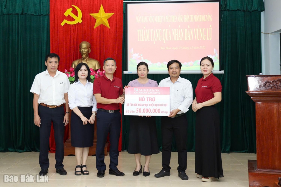 Đoàn công tác của Agribank Chi nhánh Đắk Nông trao bảng tượng trưng hỗ trợ 50 triệu đồng giúp người dân xã Tây Hòa khắc phục hậu quả mưa lũ.