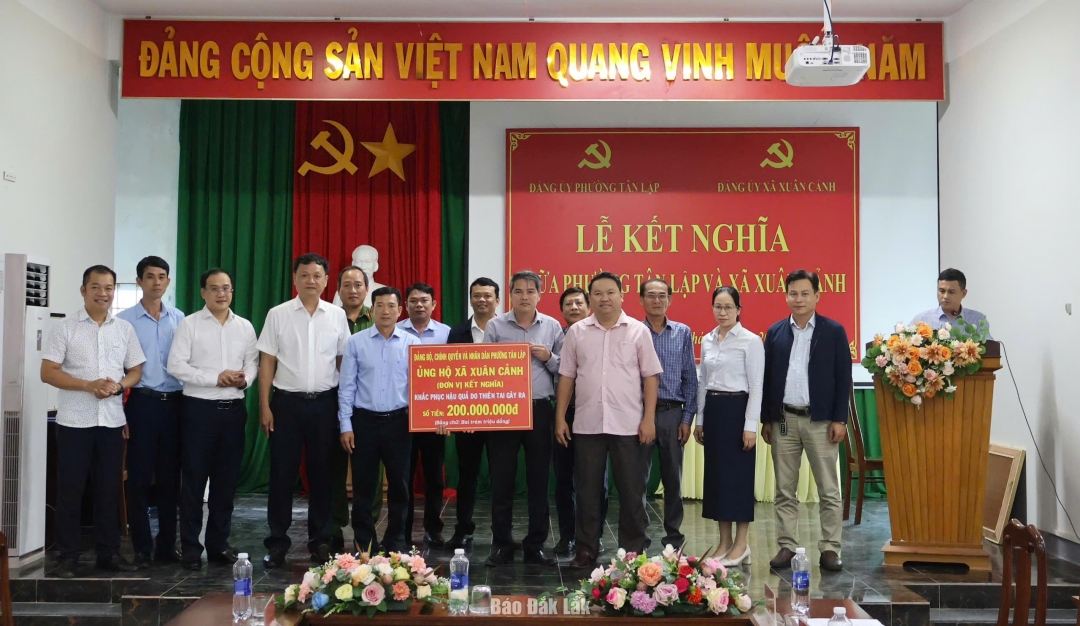 Lãnh đạo phường Tân Lập trao bảng tượng trưng 200 triệu đồng hỗ trợ xã Xuân Cảnh khắc phục hậu quả thiên tai.