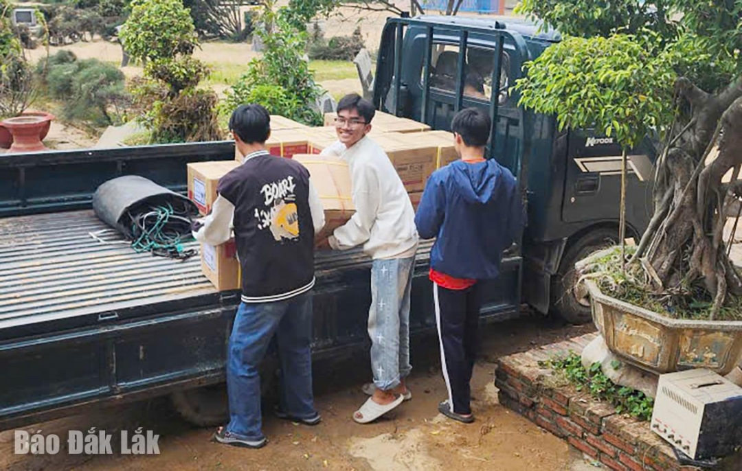 Các em học sinh Trường Tiểu học Trần Quốc Toản giúp vận chuyển quà vào trường.