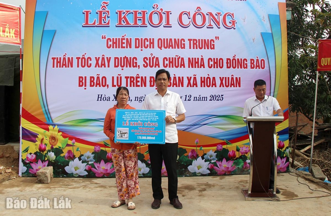 Chủ tịch UBND xã Hoàng Anh Tuấn trao bảng tượng trưng 170 triệu đồng để xây nhà cho bà Đinh Thị Rớt.