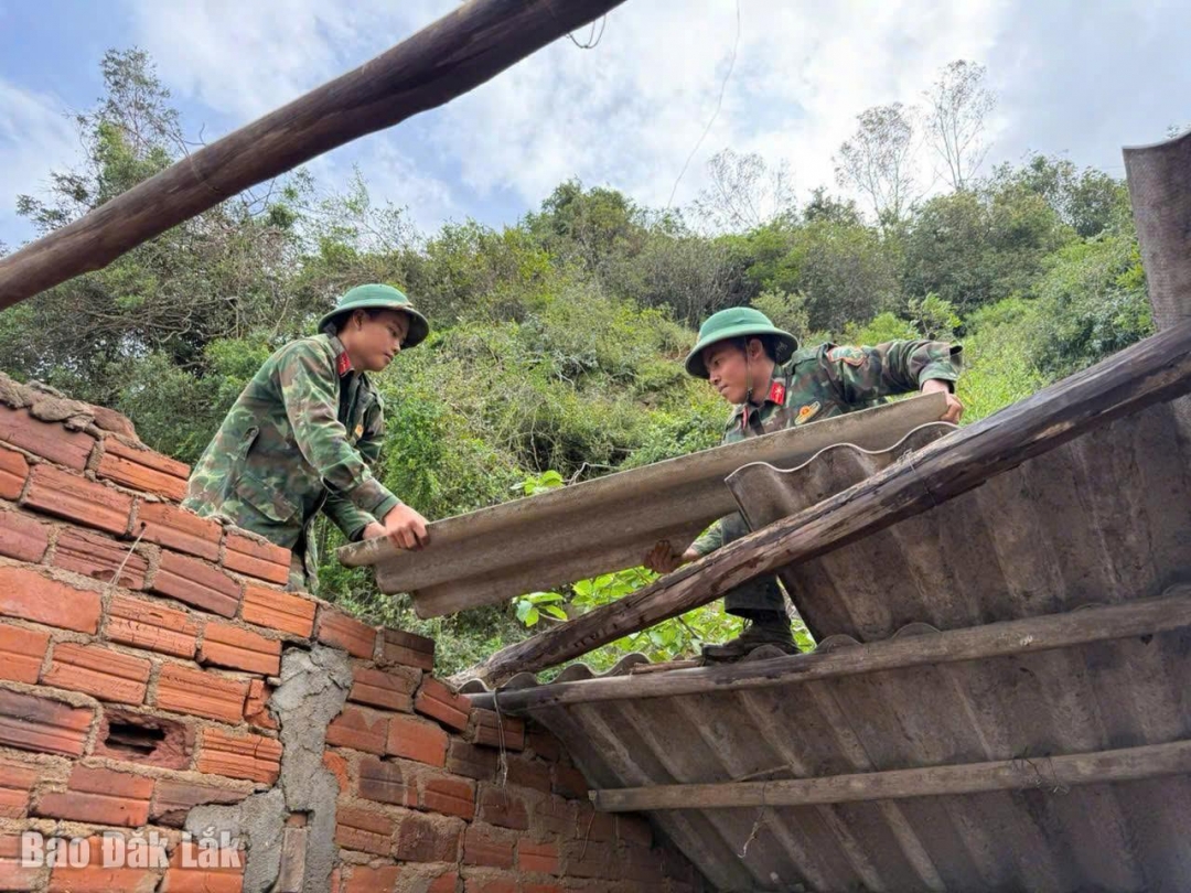 Bộ đội hỗ trợ người dân dựng lại nhà cửa sau lũ lụt.