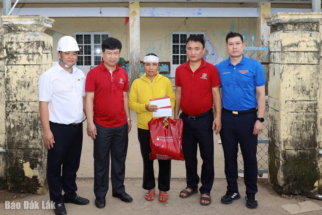 Đại diện Agribank trao quà hỗ trợ cho gia đình có người thân bị mất do mưa lũ tại xã Hòa Xuân.