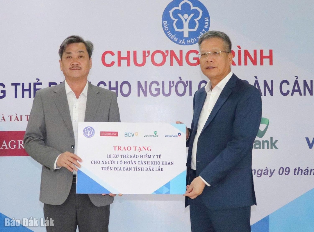 Phó Giám đốc Bảo hiểm xã hội Việt Nam Trần Đình Liệu (phải) trao bảng tượng trưng tặng 10.337 thẻ bảo hiểm y tế cho UBND tỉnh.