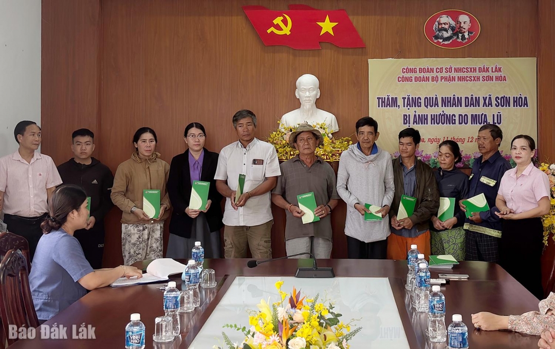 Đại diện Công đoàn cơ sở Ngân hàng Chính sách xã hội tỉnh Đắk Lắk trao quà hỗ trợ cho các hộ dân có nhà bị sập do mưa lũ ở xã Sơn Hòa.