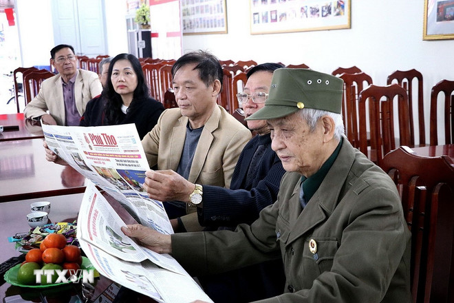 Người dân phường Hòa Bình (Phú Thọ) nghiên cứu thông tin Đại hội XIV của Đảng qua kênh báo chí. Ảnh: TTXVN