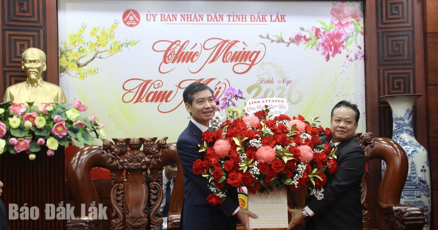 Đồng chí Thanouxay Banxalith, Phó Bí thư Tỉnh ủy, Chủ tịch Ủy ban Chính quyền tỉnh Attapeu (bên phải) tặng hoa chúc Tết tỉnh Đắk Lắk.