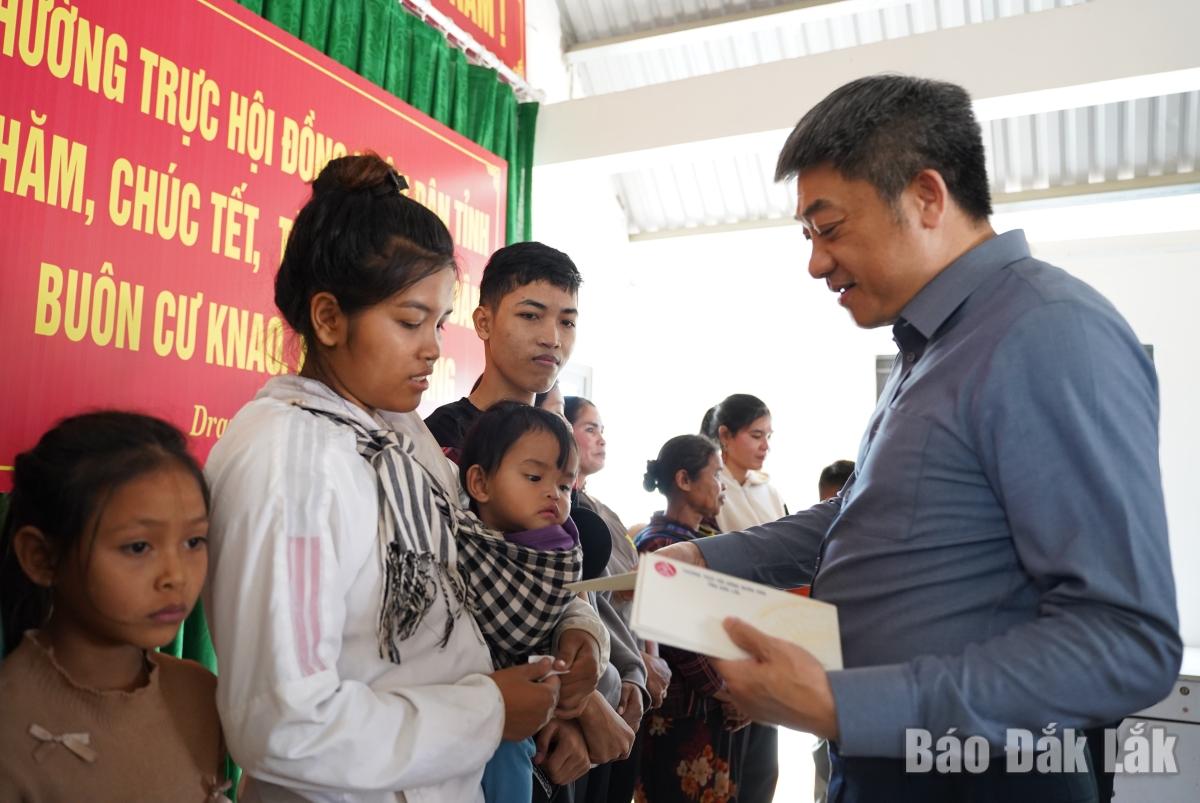 Đồng chí Từ Thái Giang, Ủy viên Ban Thường vụ Tỉnh ủy, Phó Chủ tịch Thường trực HĐND tỉnh tặng quà bà con buôn Cư Knao.