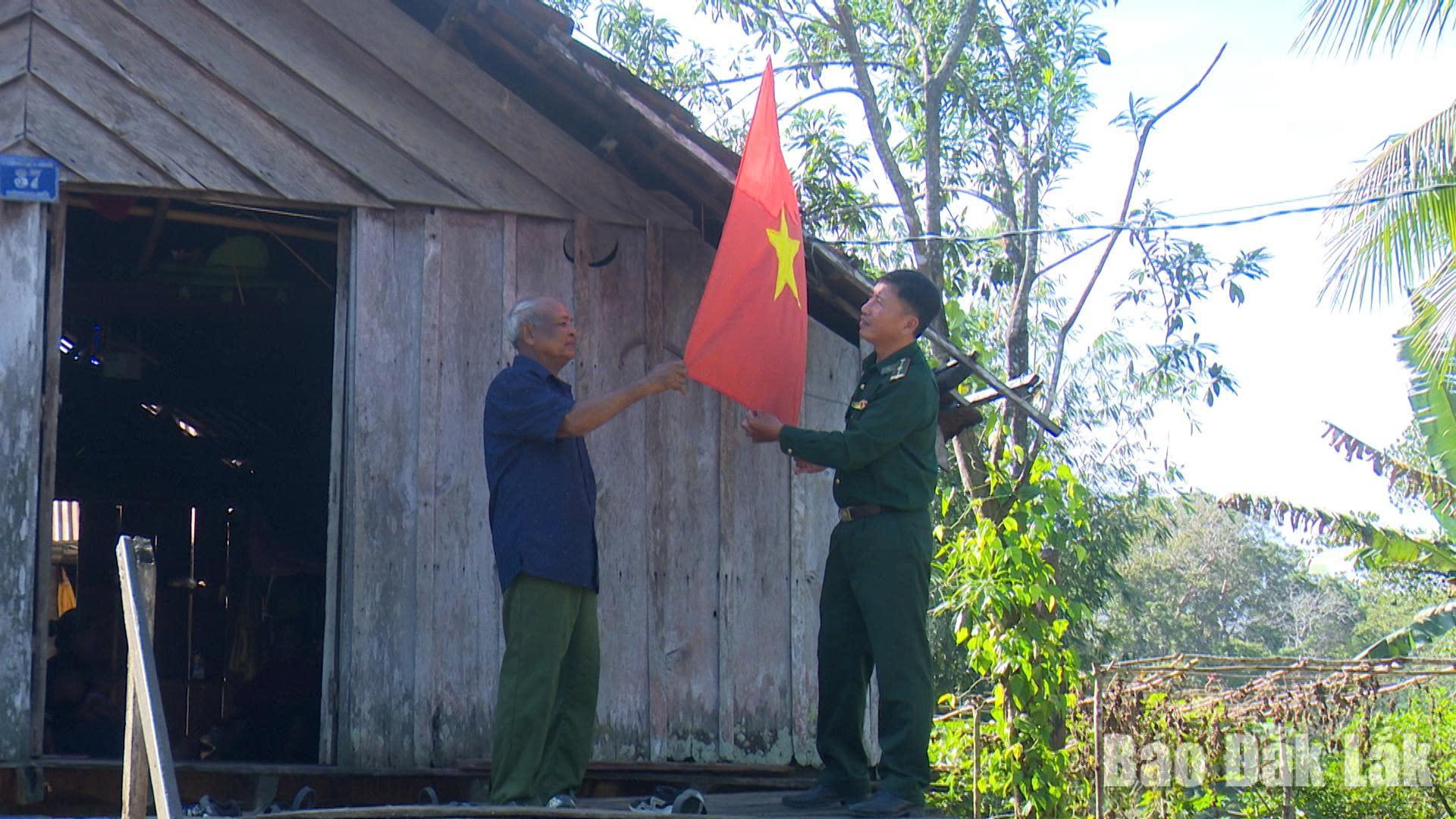 Cán bộ, chiến sĩ Đồn Biên phòng Sêrêpốk cùng người dân buôn Drang Phốk, xã Buôn Đôn treo cờ phướn chào mừng bầu cử. Ảnh: Thế Hùng.