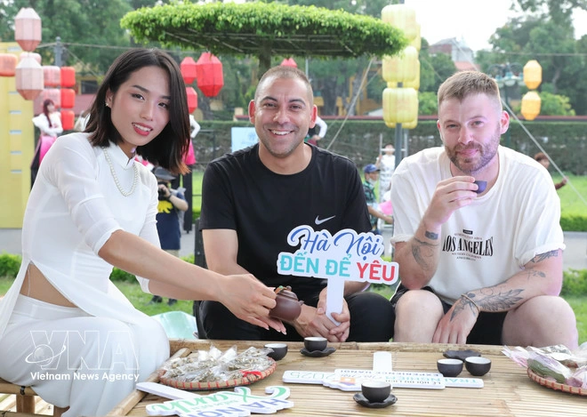 Foreign tourists experience drinking West Lake lotus-infused tea at the Thang Long Imperial Citadel in Hanoi. (Photo: VNA)