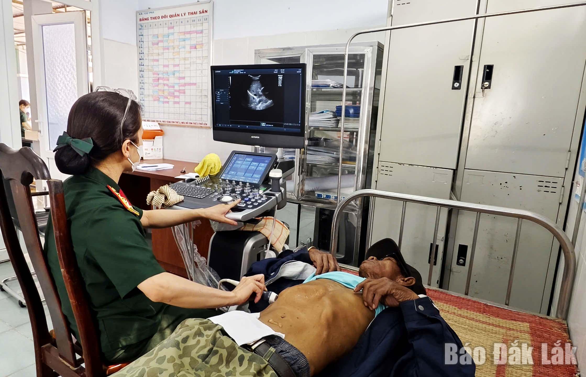 Y, bác sĩ Bệnh xá Quân Dân y siêu âm cho người dân xã Cư Pui.