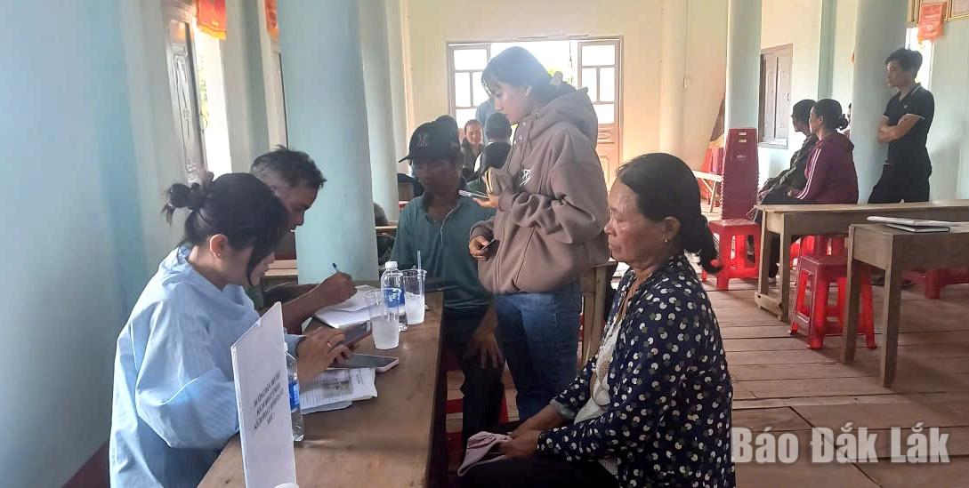 Thành viên tổ hỗ trợ lưu động hướng dẫn người dân buôn Ea Sar thực hiện các thủ tục hành chính trực tuyến.