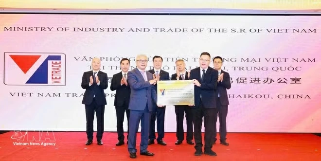 A leader of the Hainan Department of Commerce presents the office plaque to the Chief Representative of the Vietnam Trade Promotion Office in Haikou, Hainan. (Photo: VNA)