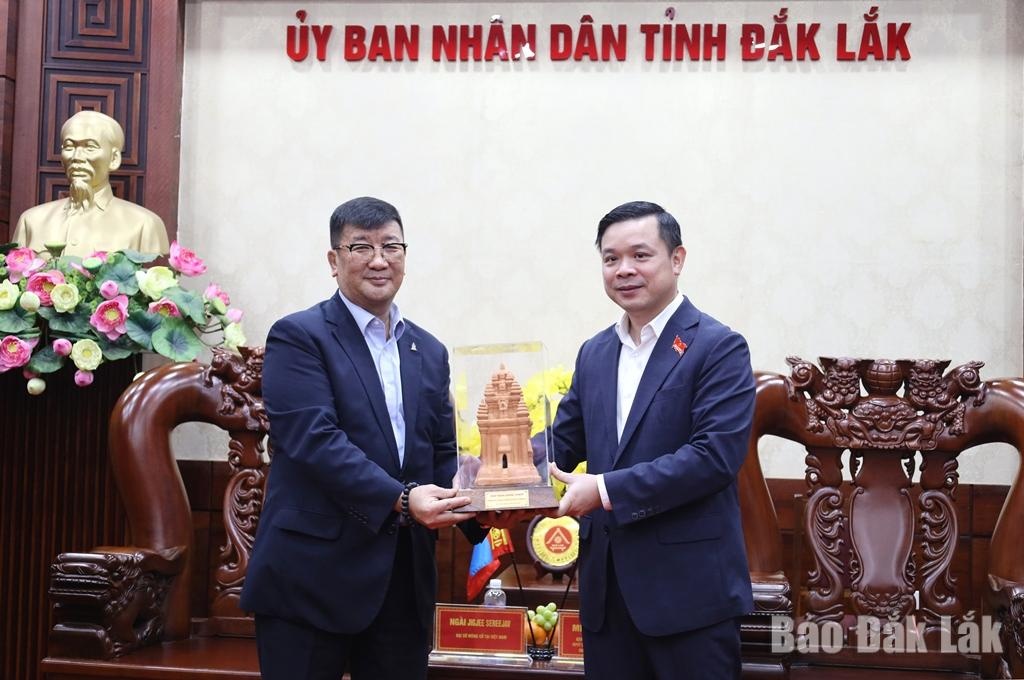 Comrade Do Huu Huy presenting a commemorative gift to Ambassador Jigjee Sereejav.