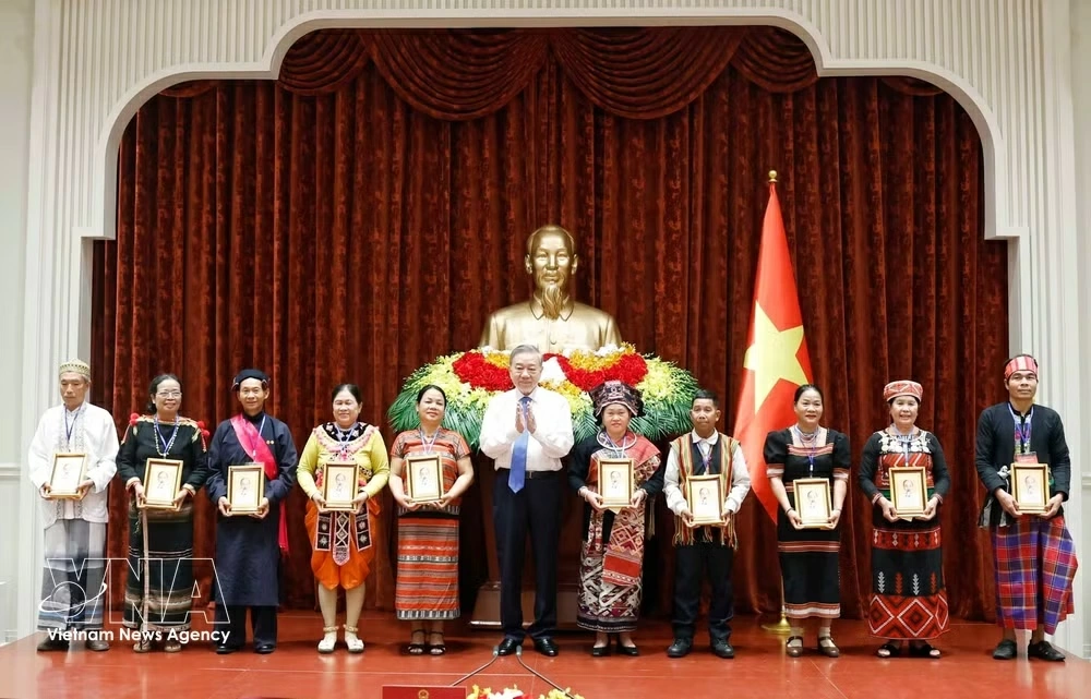 Party General Secretary and State President To Lam presents portraits of late President Ho Chi Minh to village elders, community leaders, artisans, and prominent figures of ethnic minorities at the meeting in Hanoi on April 18. (Photo: VNA)