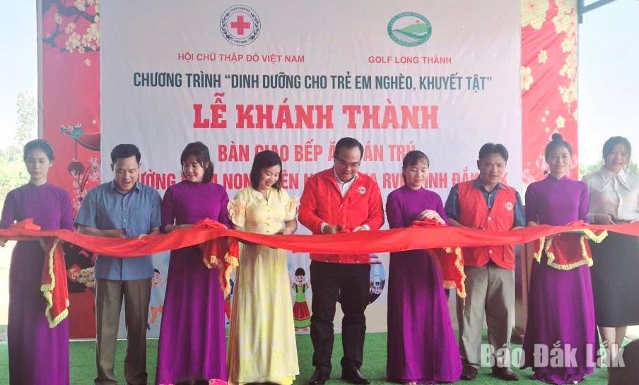 Các đồng chí lãnh đạo các đơn vị cắt băng khánh thành và bàn giao bến ăn bán trú cho trường Mầm non Thiên Nga.