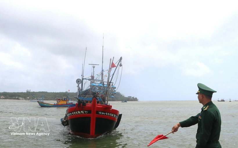 A border guard requests a fishing vessel to dock for verification of its entry and exit logs (Photo: VNA)