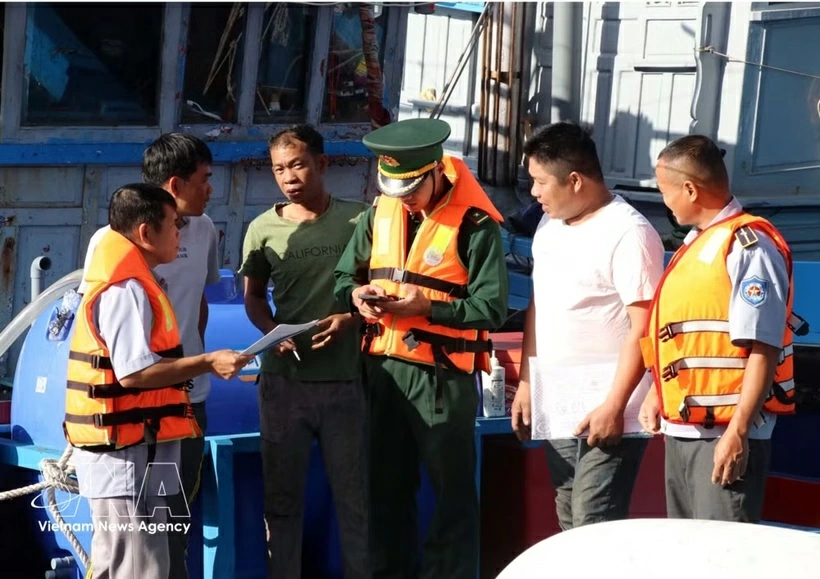 Officers from the Ca Na border guard station and the management board of Ca Na fishing port in Khanh Hoa province inspect documents related to fishermen’s vessels. (Photo: VNA)