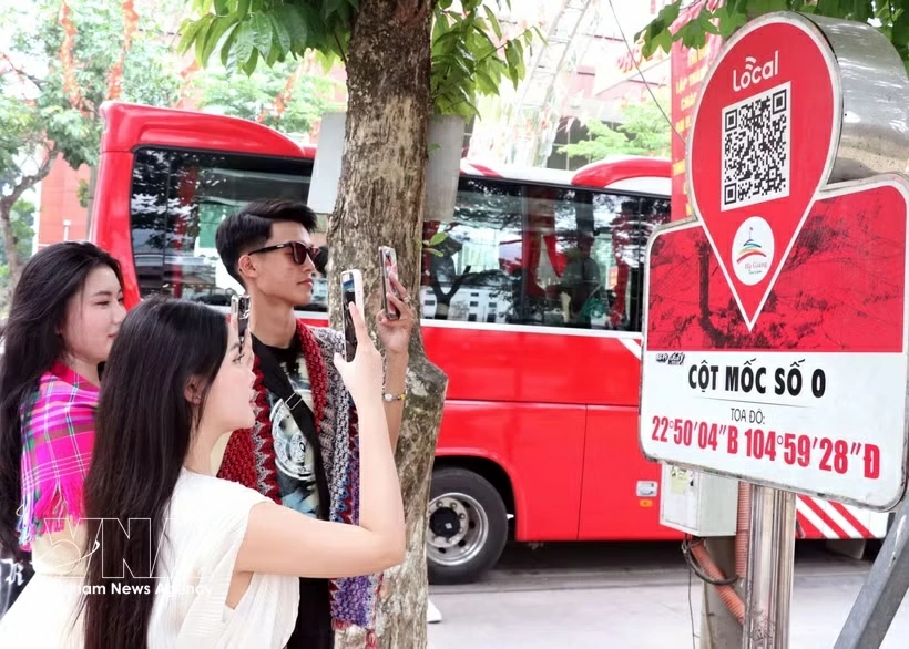 Visitors scan a QR code on the Km0 Ha Giang marker to access tourism information. (Photo: VNA)