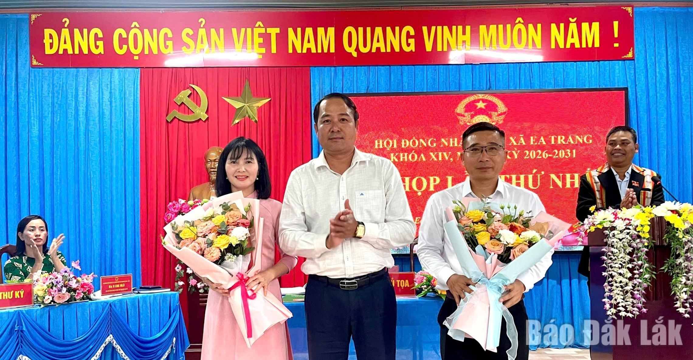 Đồng chí Y Nhuân Byă, Phó Trưởng Ban Tổ chức Tỉnh ủy tặng hoa chúc mừng Chủ tịch HĐND xã và Trưởng Ban Kinh tế - Ngân sách HĐND xã Ea Trang.