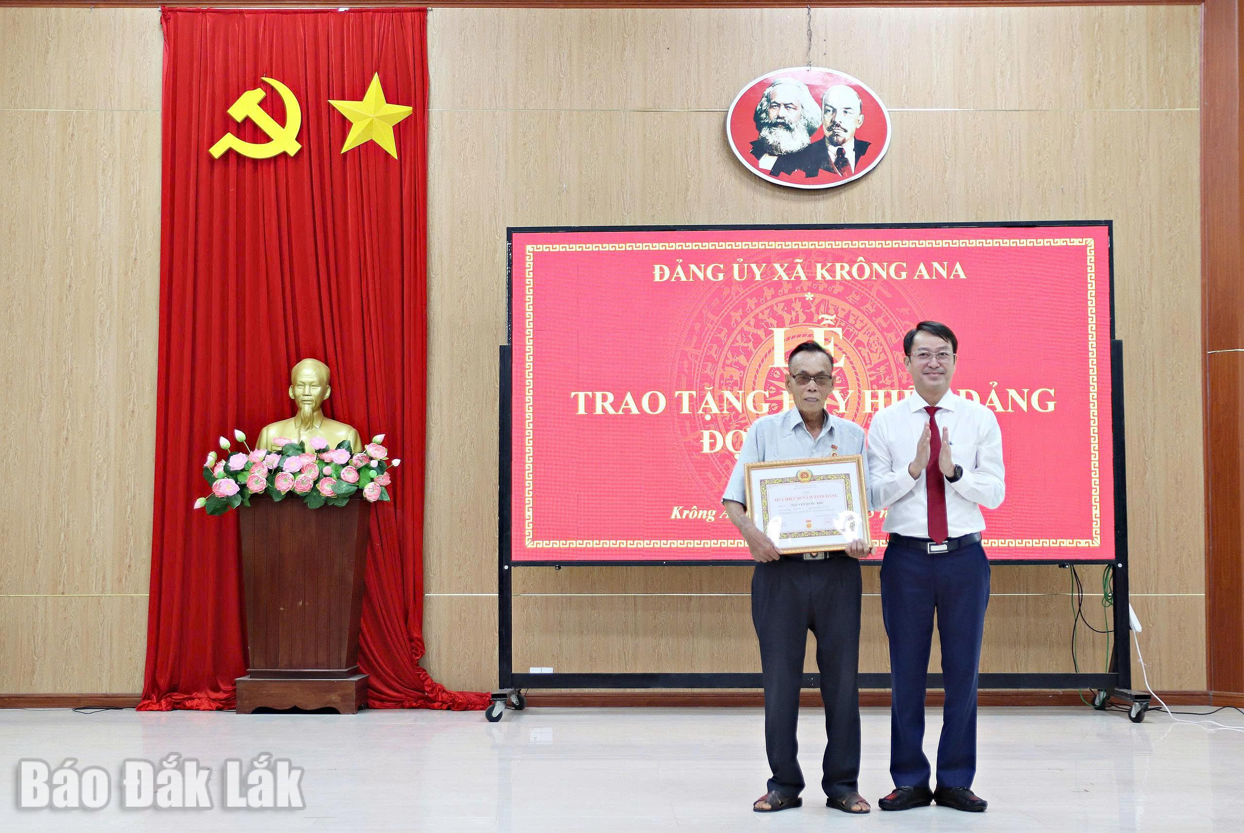 Bí thư Đảng ủy, Chủ tịch HĐND xã Trần Văn Quế trao Huy hiệu 60 năm tuổi Đảng cho đồng chí Hoàng Đình Hồng, đảng viên Chi bộ thôn 8.