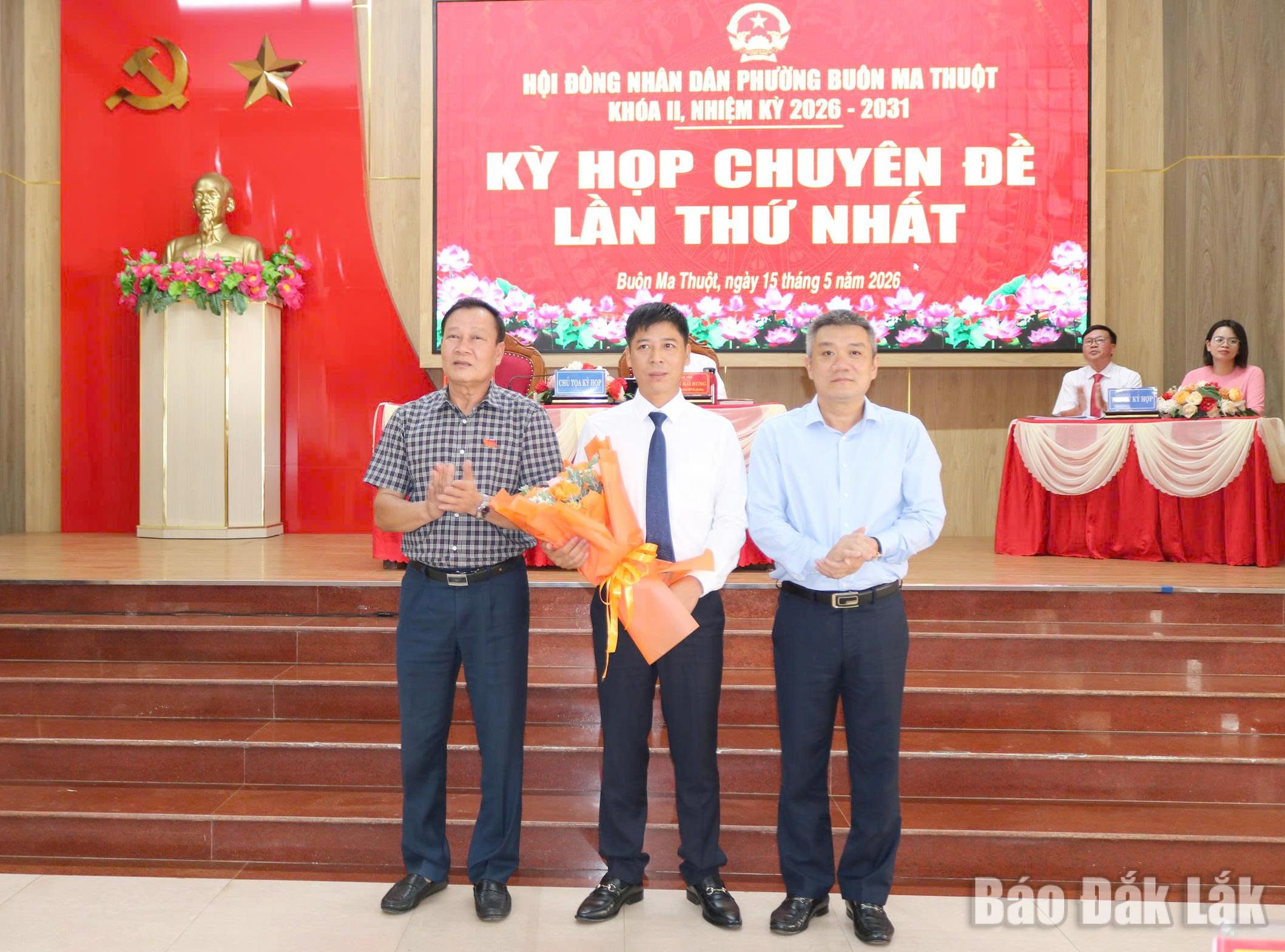 Đồng chí Trần Phú Hùng, Ủy viên Ban Thường vụ Tỉnh ủy, Bí thư Đảng ủy, Chủ tịch HĐND phường và đồng chí Nguyễn Thanh Vũ, Phó Bí thư Đảng ủy, Chủ tịch UBND phường Buôn Ma Thuột tặng hoa chúc mừng tân Phó Chủ tịch UBND phường Đinh Văn Quán.