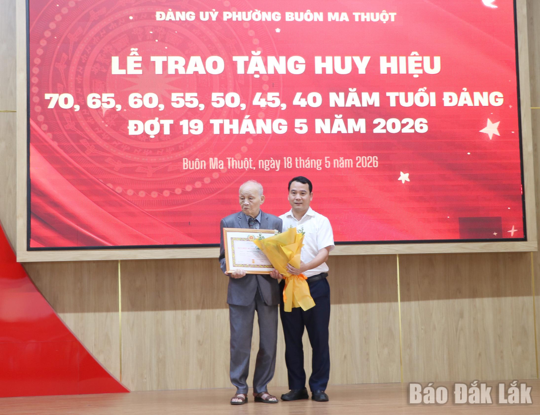 Phó Bí thư Thường trực Đảng ủy phường Buôn Ma Thuột trao Huy hiệu 65 năm tuổi Đảng cho đảng viên Trần Văn Thân, Chi bộ Tổ dân phố 1A Thành công.