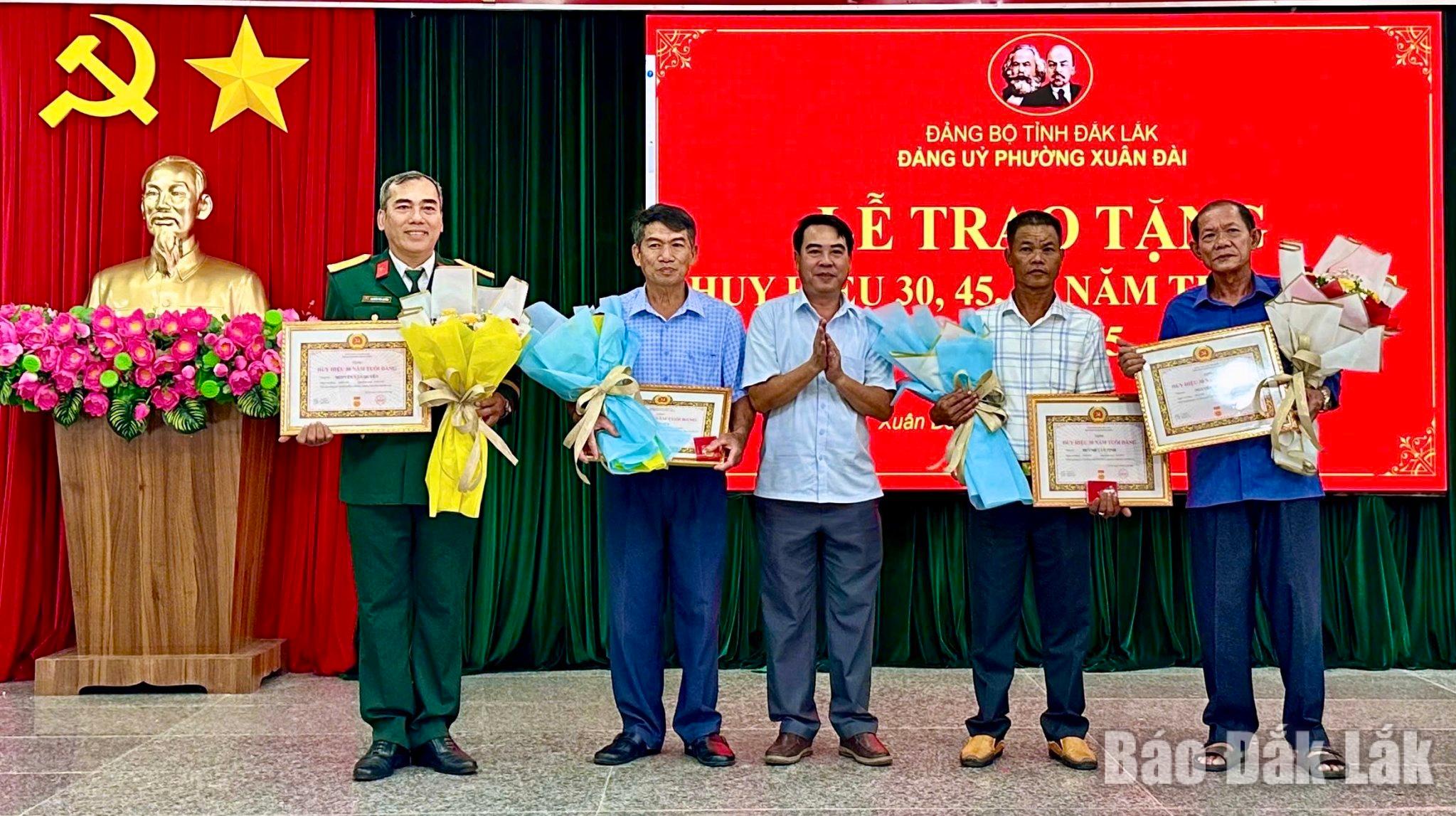 Bí thư Đảng ủy, Chủ tịch HĐND phường Xuân Đài Hồ Hồng Nam trao Huy hiệu Đảng đợt 19/5 cho các đảng viên.