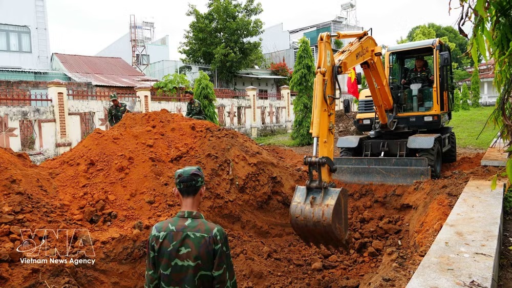 Officers and soldiers of Team K53 excavate survey trenches during search and recovery operations. (Photo: VNA)