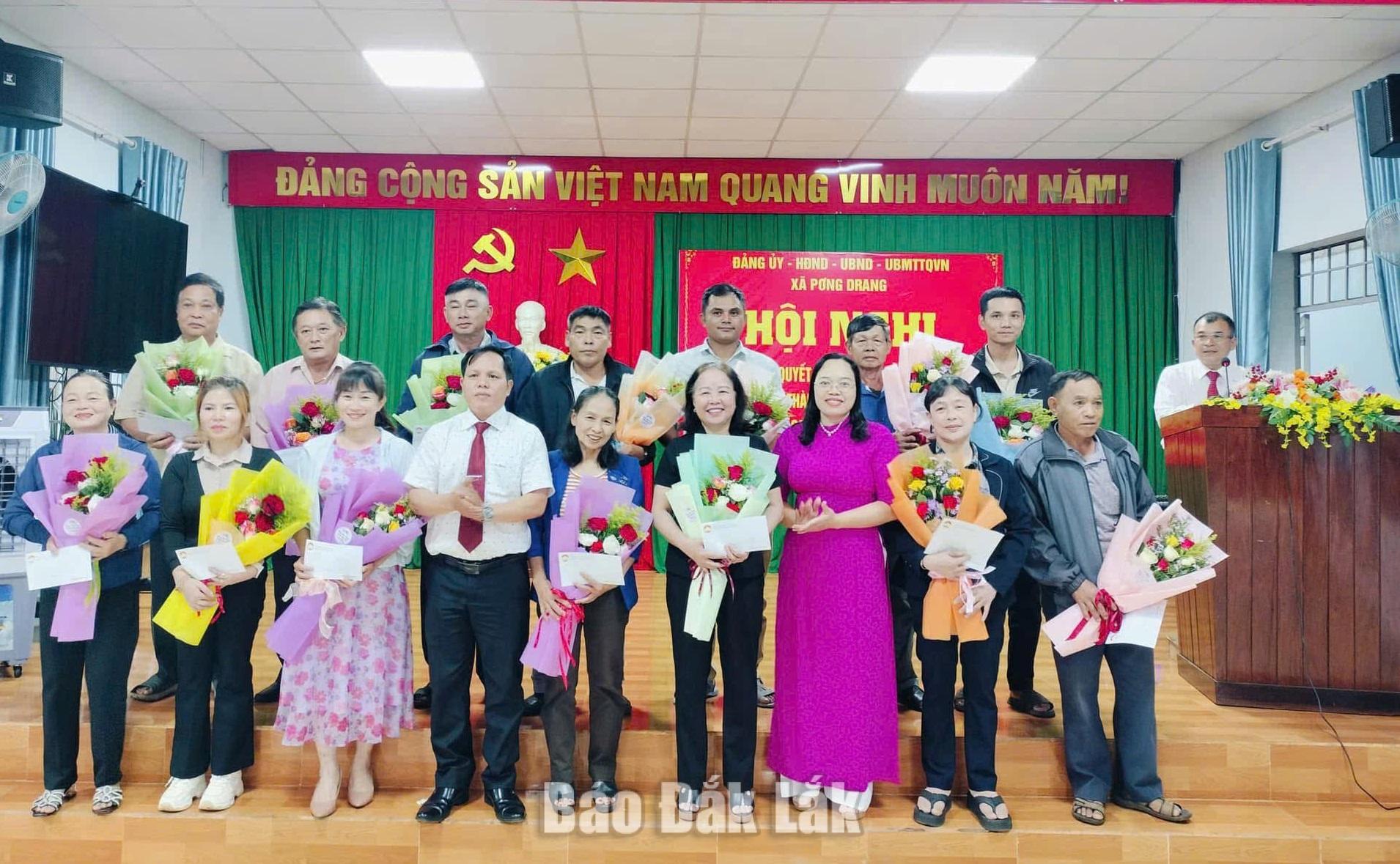 Lãnh đạo xã Pơng Drang tặng hoa chúc mừng cán bộ các thôn mới.