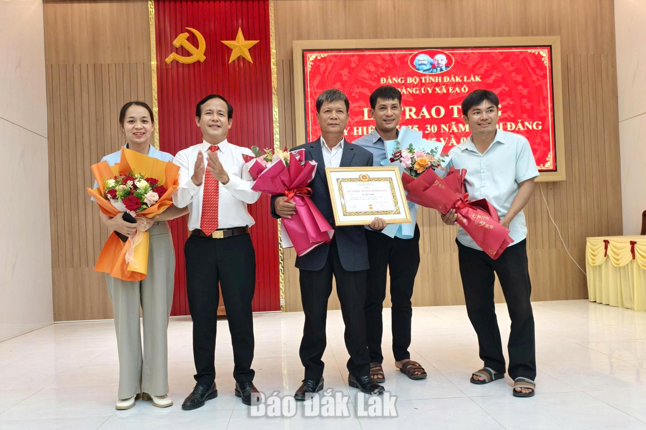 Phó Bí thư Thường trực Đảng ủy xã Ea Ô Nguyễn Ngọc Trí trao Huy hiệu 35 năm tuổi Đảng cho đảng viên.