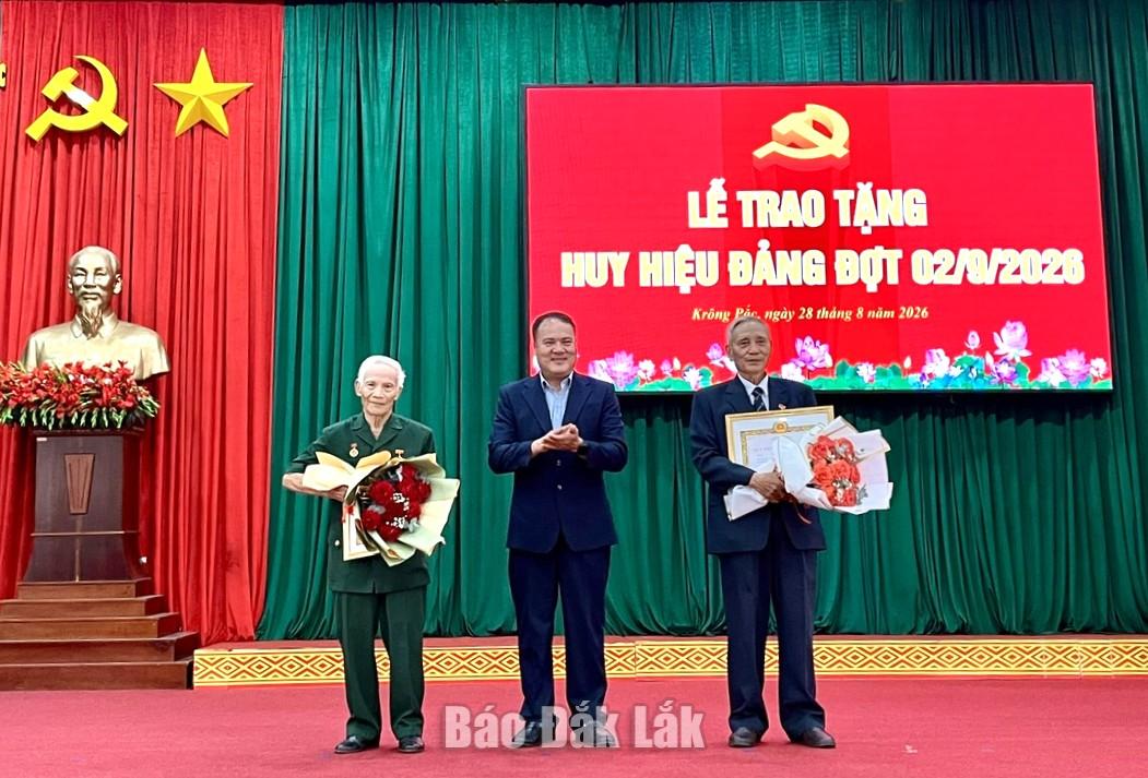 Bí thư Đảng ủy, Chủ tịch HĐND xã Phạm Văn Lập trao Huy hiệu Đảng cho các đảng viên.