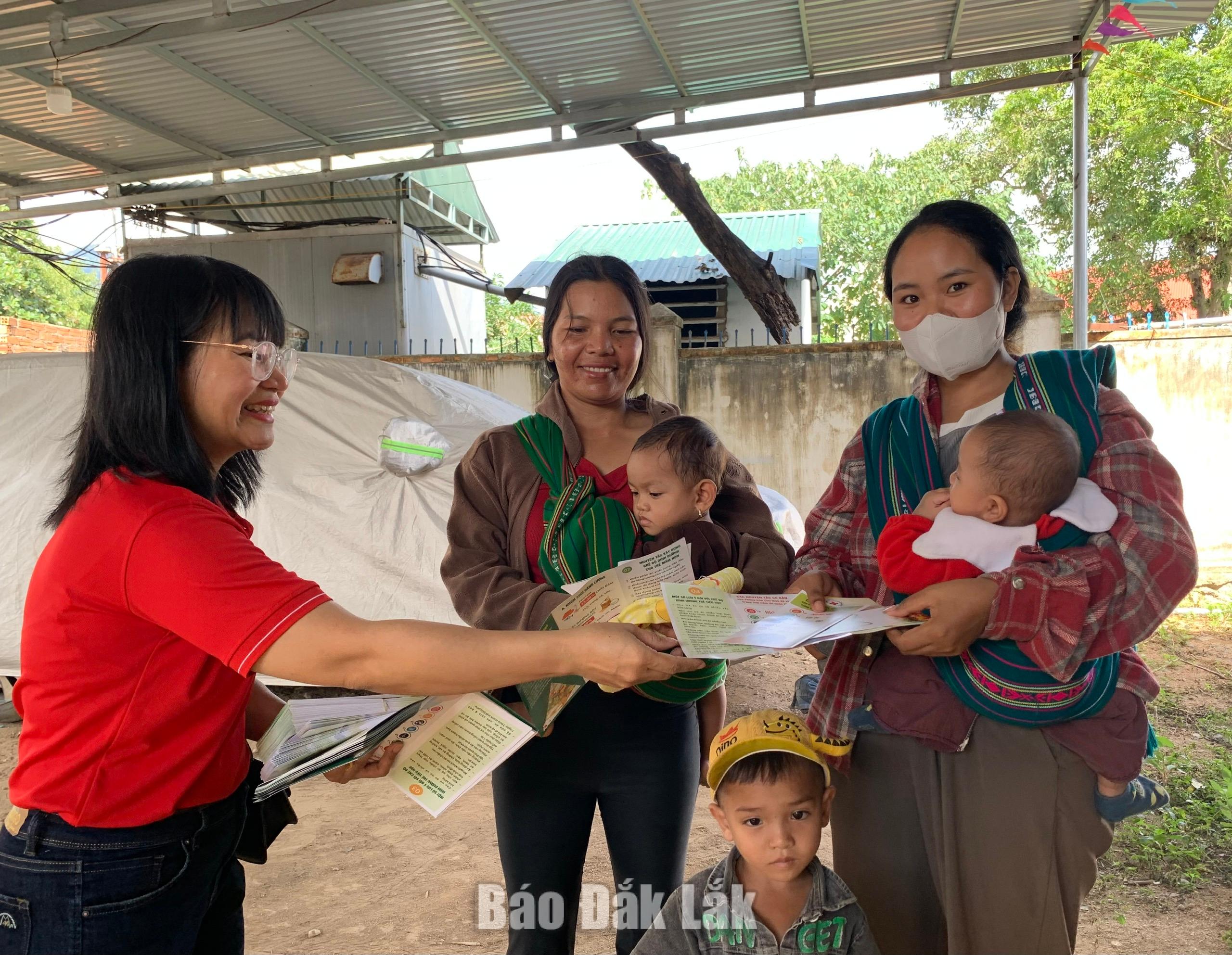 Tình nguyện viên chữ thập đỏ phát tờ rơi tuyên truyền về dinh dưỡng cho người dân xã Yang Mao.