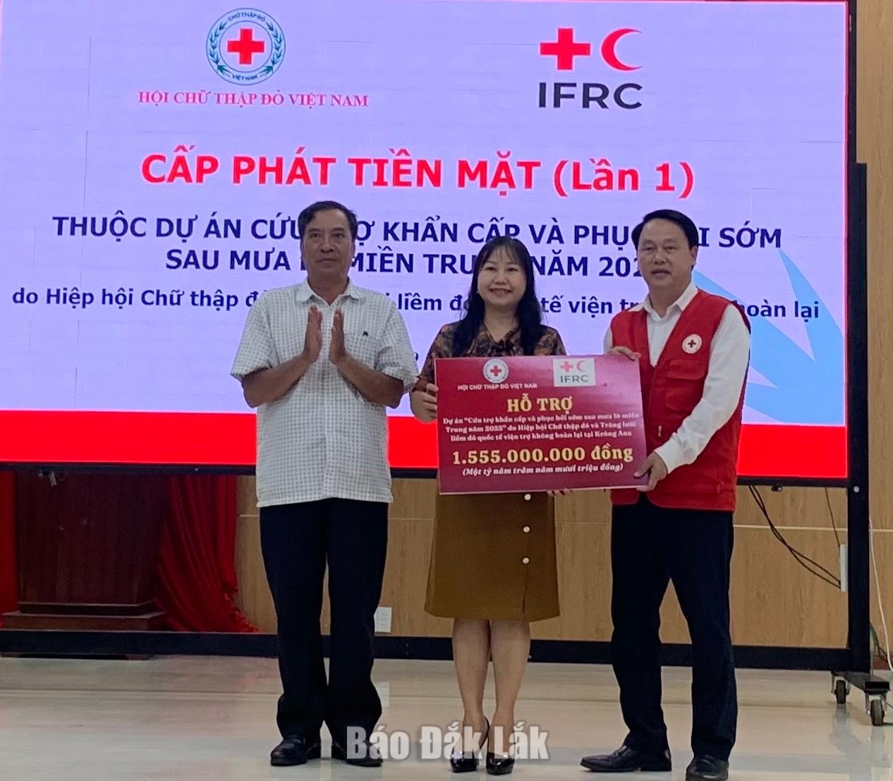 Chủ tịch Hội Chữ thập đỏ tỉnh Đắk Lắk Nguyễn Đình Nam (bìa phải) trao kinh phí hỗ trợ cho người dân xã Krông Ana phục hôi sinh kế.
