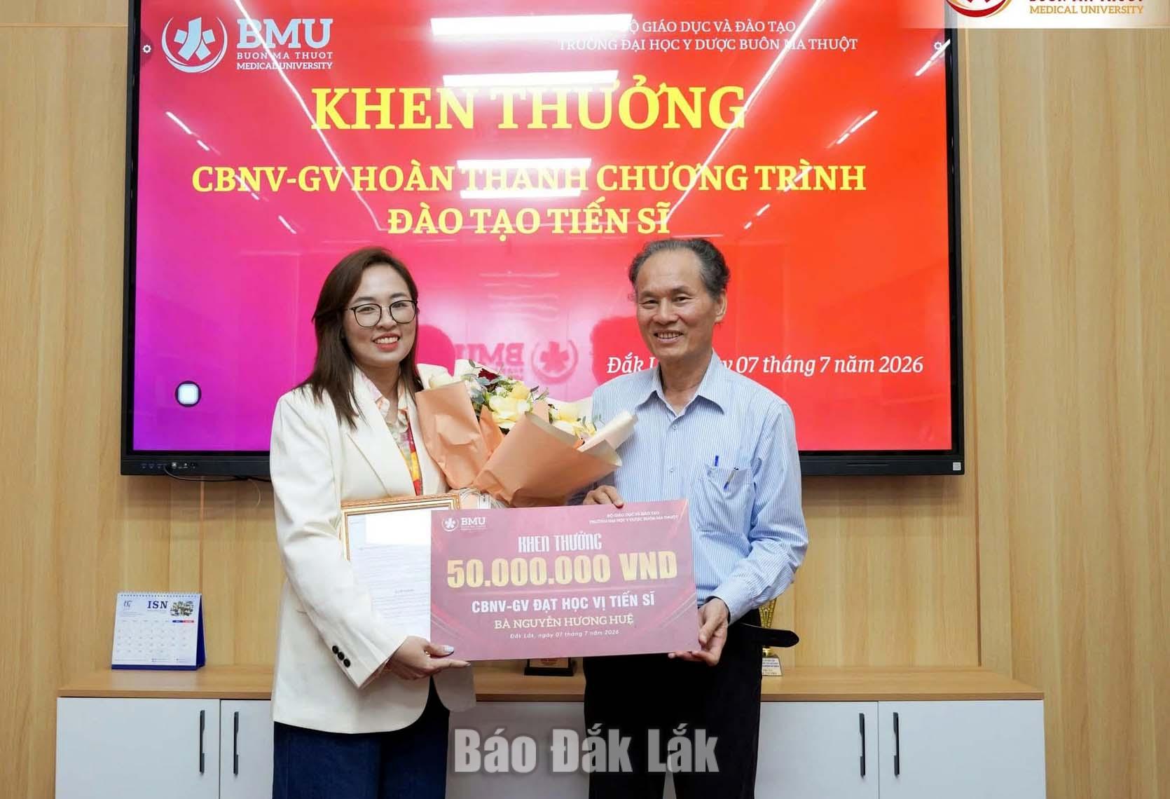 Giáo sư, Tiến sĩ Cao Tiến Đức, Hiệu trưởng Trường Đại học Y Dược Buôn Thuột khen thưởng cho một tân tiến sĩ của trường.