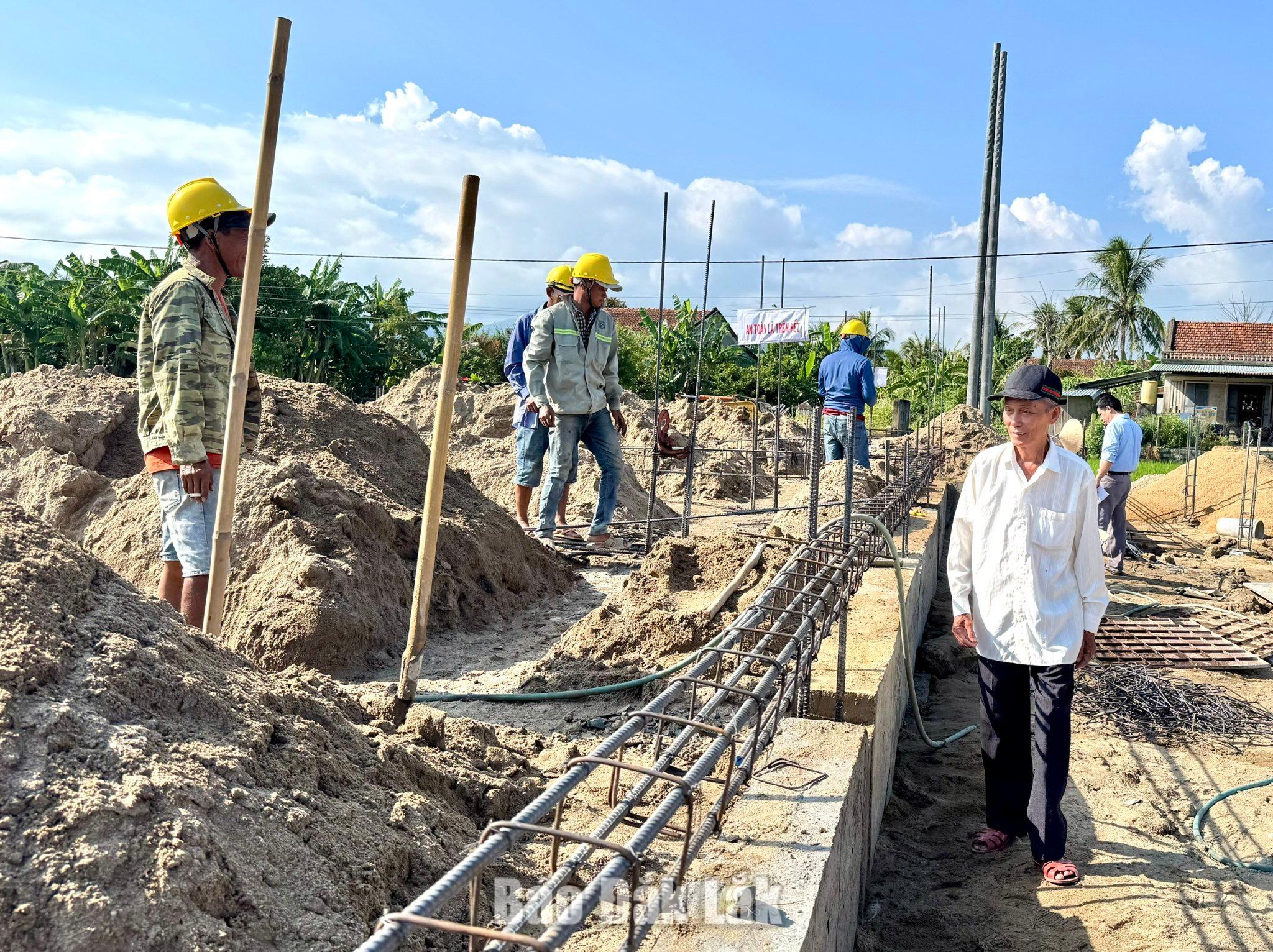Ông Nguyễn Liễm (bên phải) thăm công trình nhà sinh hoạt cộng đồng kết hợp phòng tránh lũ đang được xây dựng 
trên phần đất hơn 400 m² do gia đình ông tự nguyện hiến tặng. 