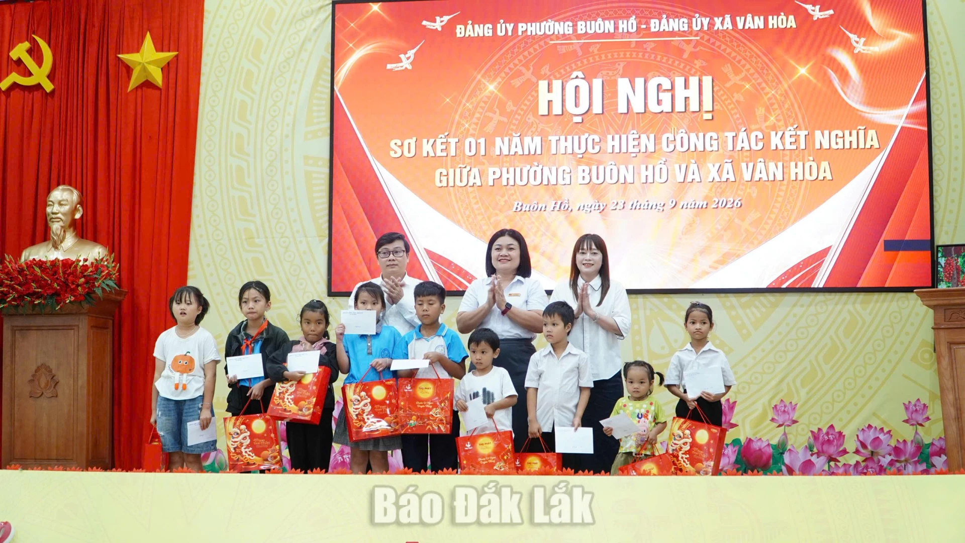Đại diện lãnh đạo hai địa phương tặng quà cho trẻ em phường Buôn Hồ vượt khó vươn lên trong học tập