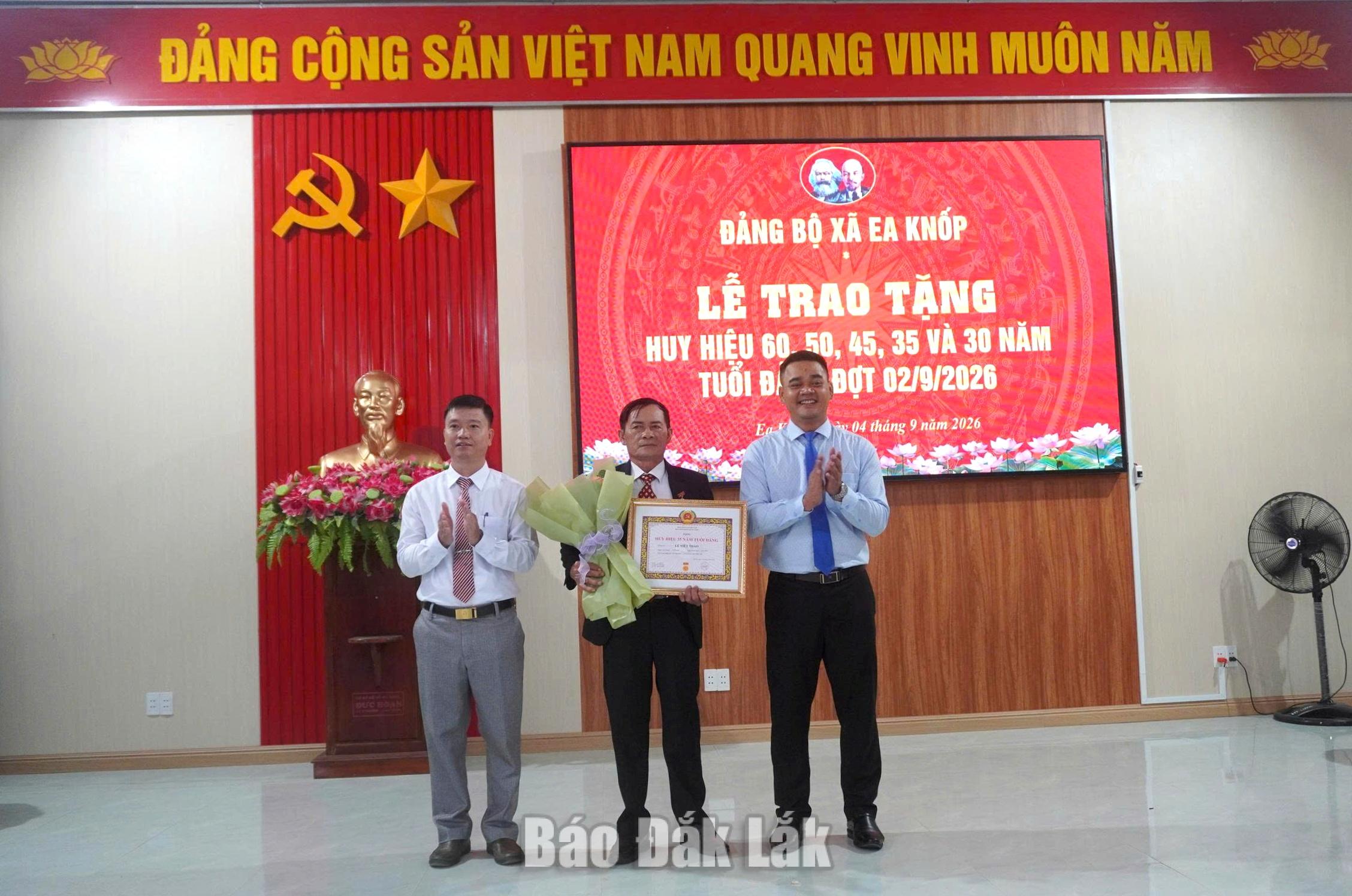 Bí thư Đảng ủy, Chủ tịch HĐND xã Ea Knốp Mlô Bren và Nguyễn Văn Hải, Phó Bí thư Thường trực Đảng ủy xã trao tặng Huy hiệu Đảng cho đảng viên.