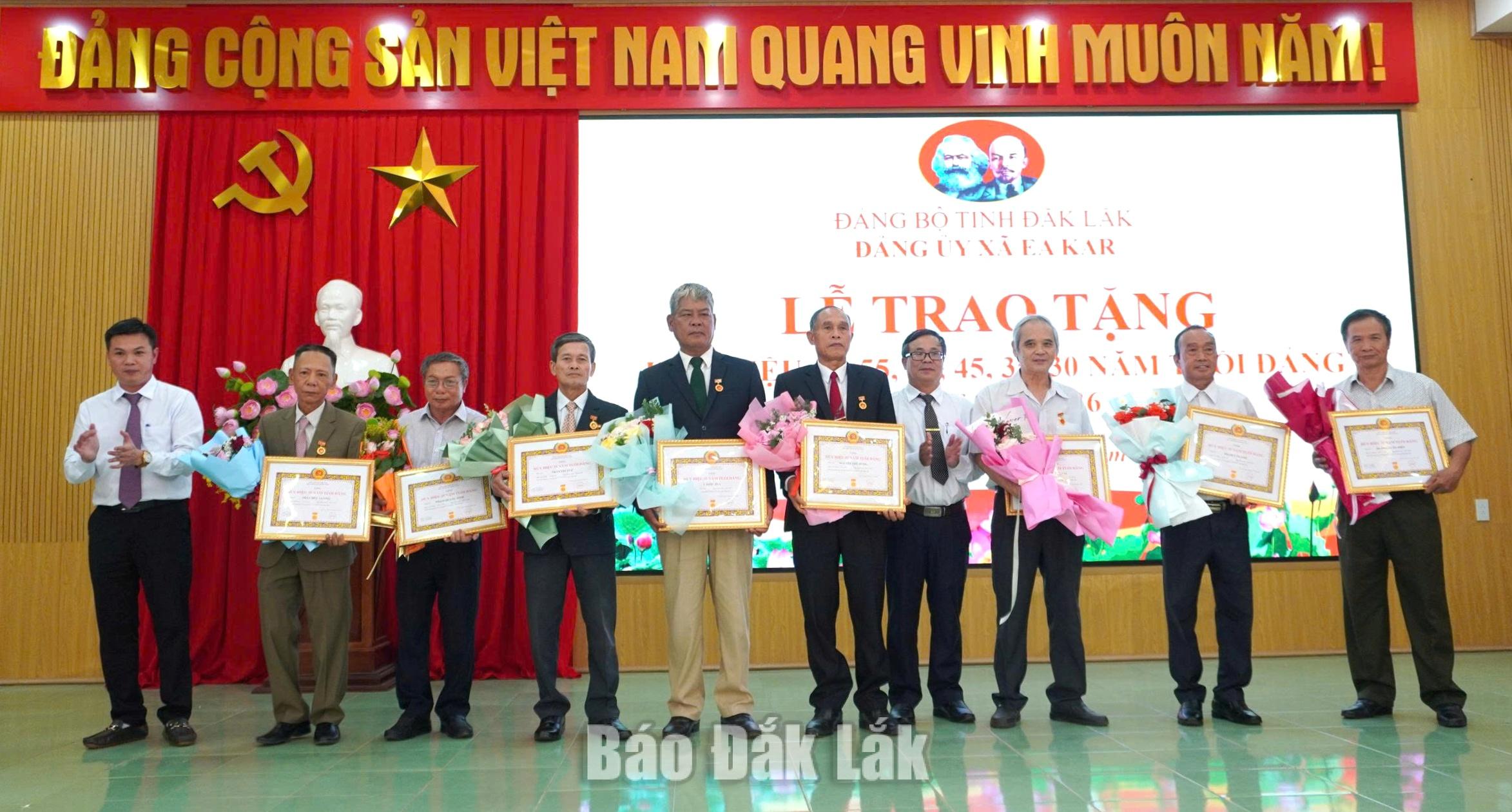 Phó Bí thư Thường trực Đảng ủy xã Nguyễn Thành Trung và Trưởng Ban Xây dựng Đảng xã Ea Kar Phạm Ngọc Tăng trao Huy hiệu 30 năm tuổi Đảng cho các đảng viên.