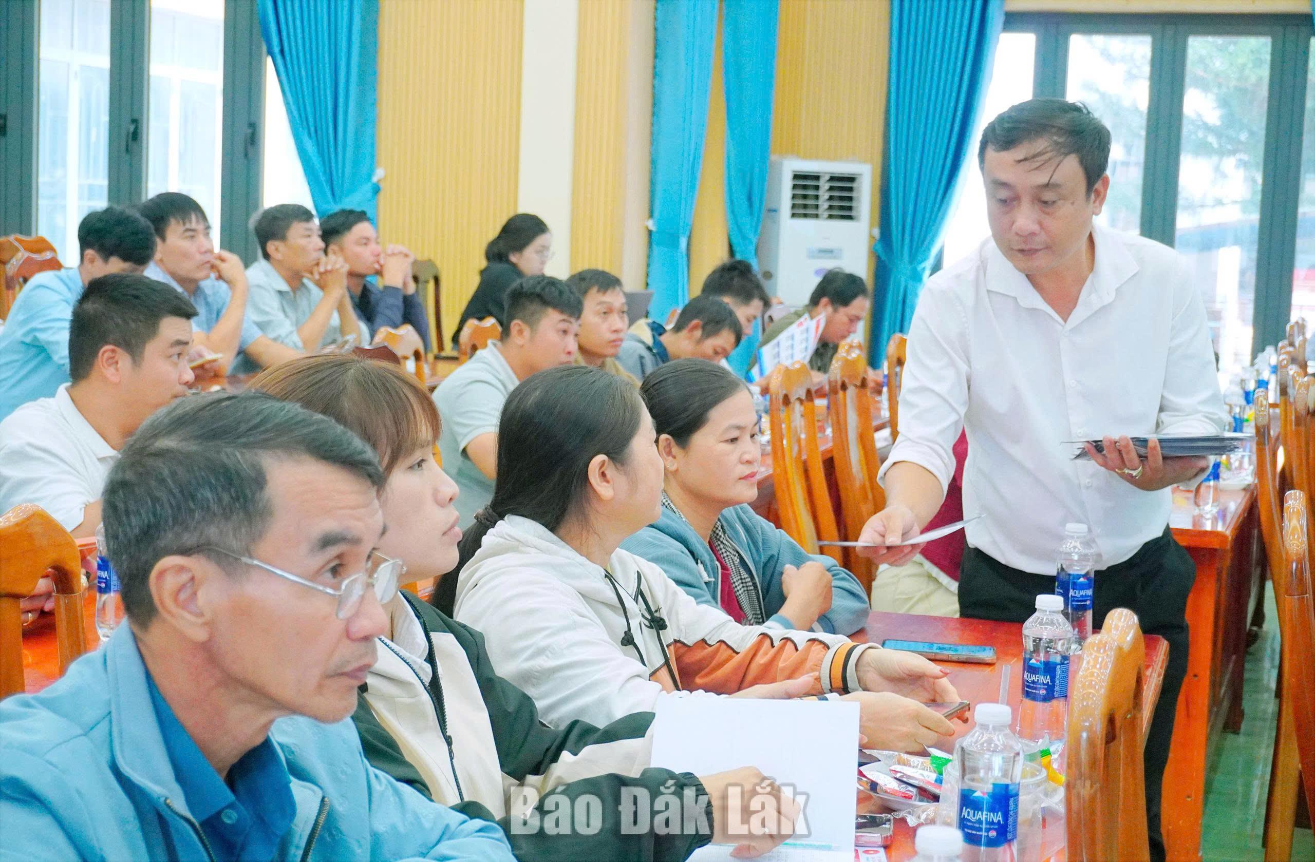 Cán bộ xã Ea Kar phát tờ rơi hướng dẫn cách sử dụng nền tảng số và hỗ trợ người dân thực hiện dịch vụ công trực tuyến.