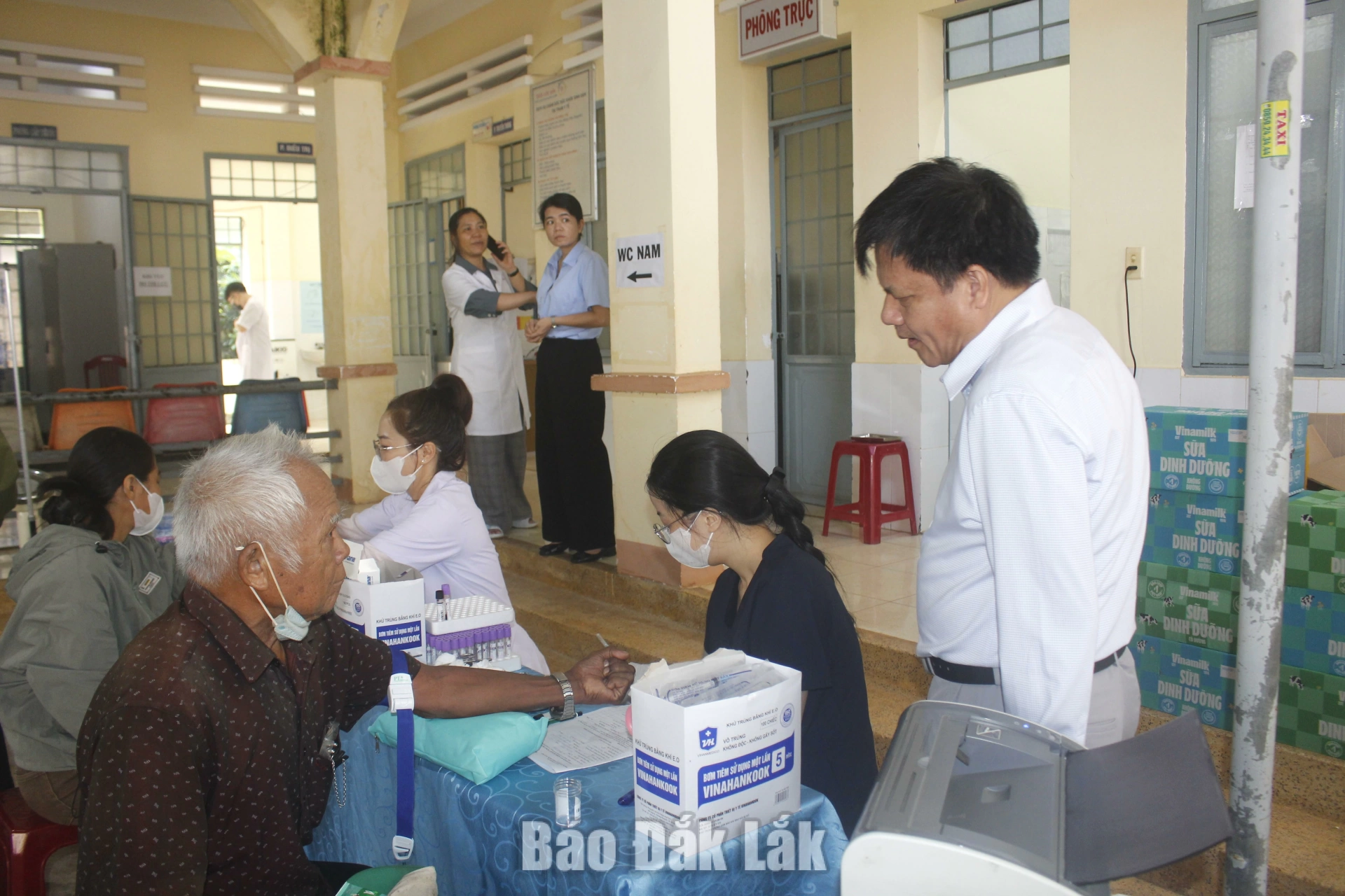 Ông Đặng Văn Bằng, Bí thư Đảng ủy, Chủ tịch HĐND xã Ea Nuôl (bìa phải) thăm hỏi tình hình sức khỏe bà con.