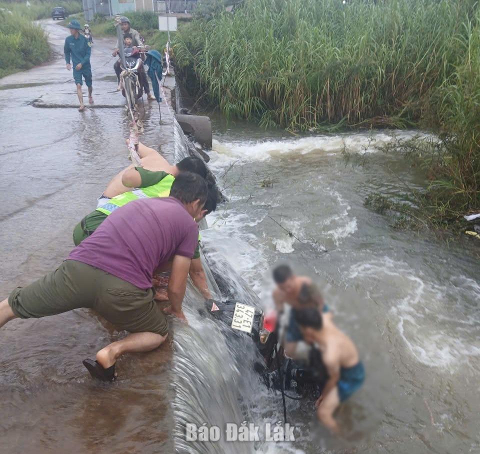 Các lực lượng phối hợp đưa chiếc xe bị nước cuốn lên khỏi khu vực cầu tràn.