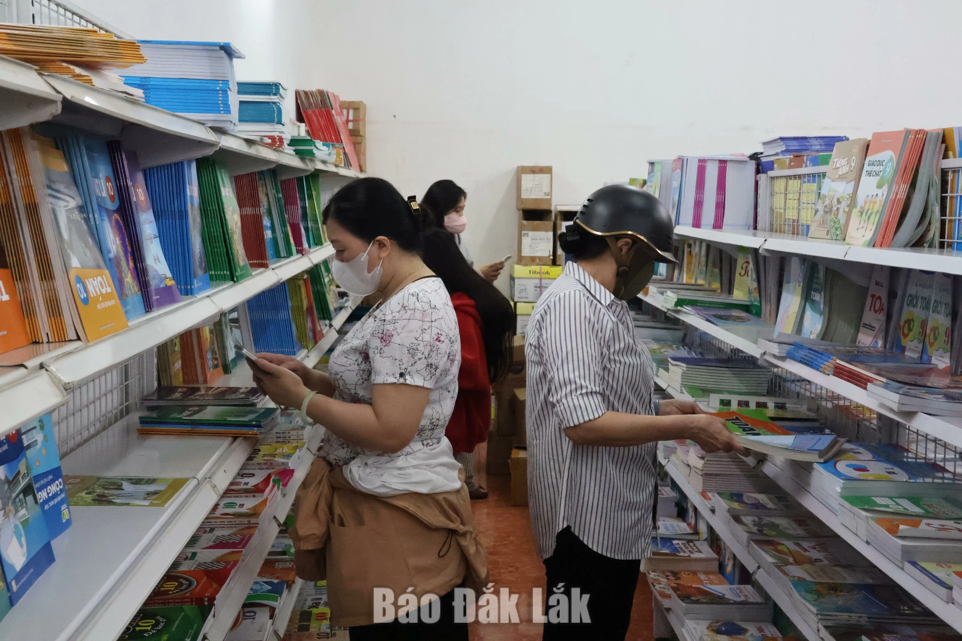 Phụ huynh tìm mua sách tại một nhà sách ở phường Buôn Ma Thuột.