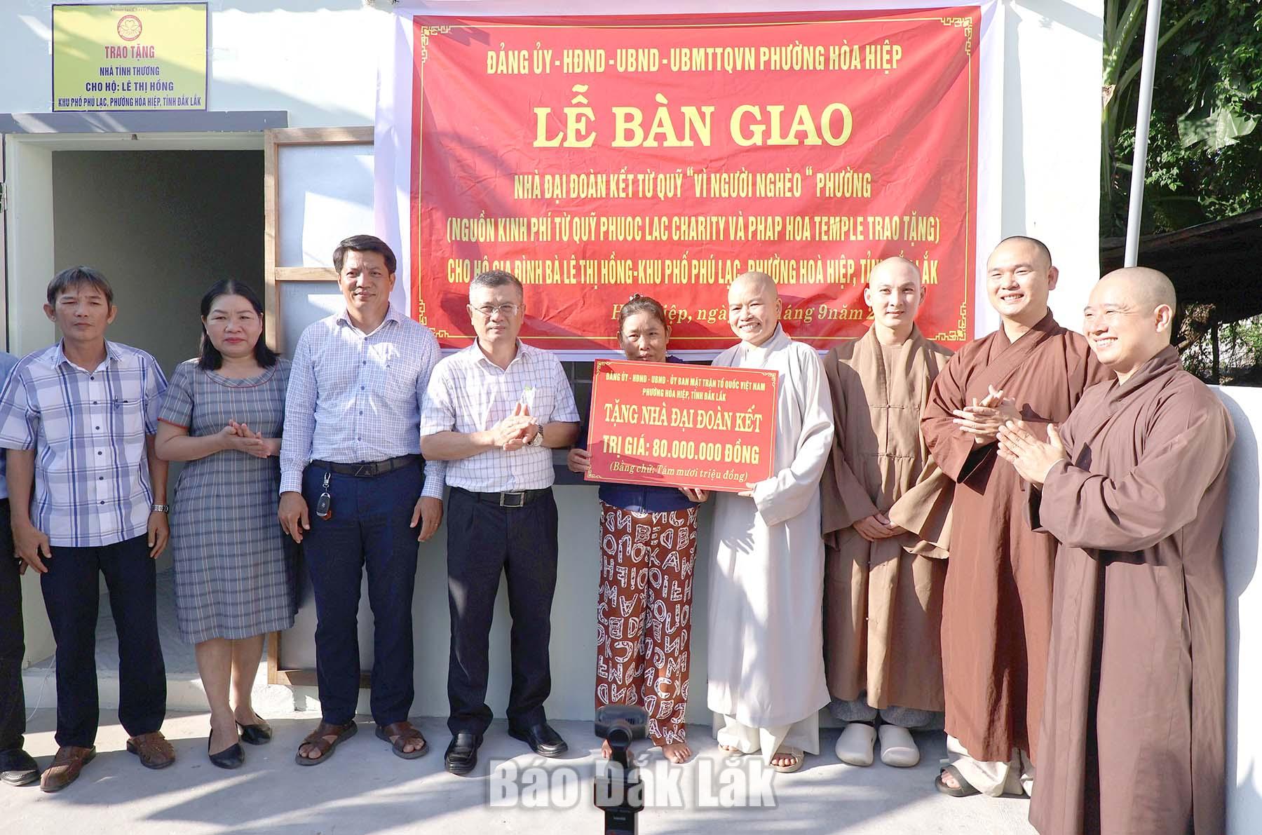 Lãnh đạo địa phương và các nhà hảo tâm trao bảng hỗ trợ kinh phí xây dựng Nhà Đại đoàn kết cho gia đình bà Lê Thị Hồng.