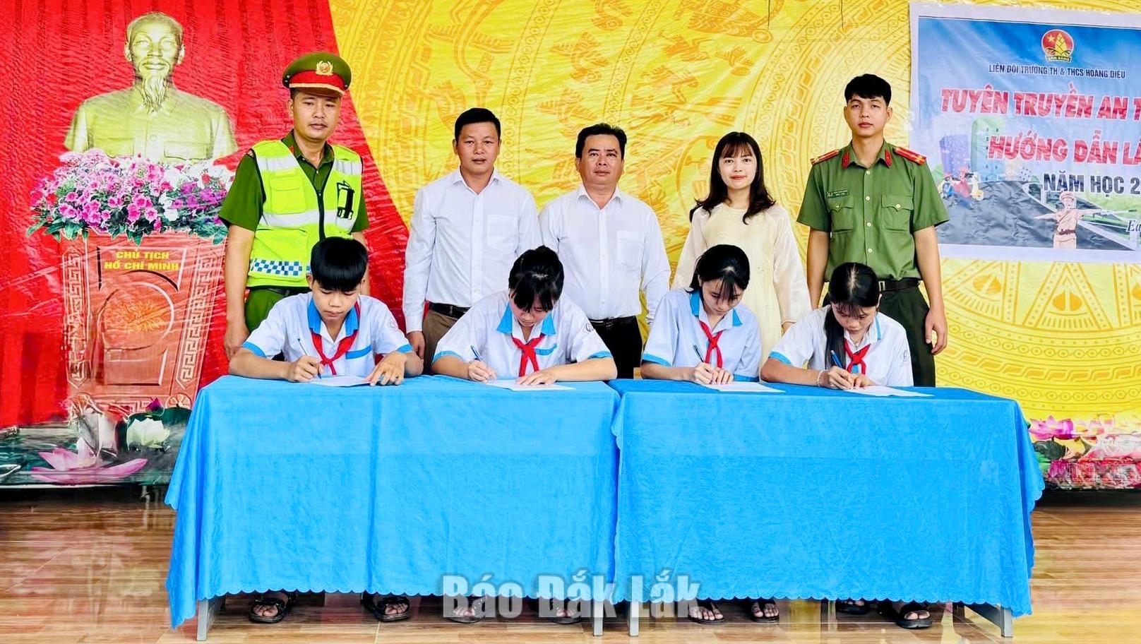 Đại diện học sinh ký cam kết chấp hành pháp luật về trật tự an toàn giao thông.