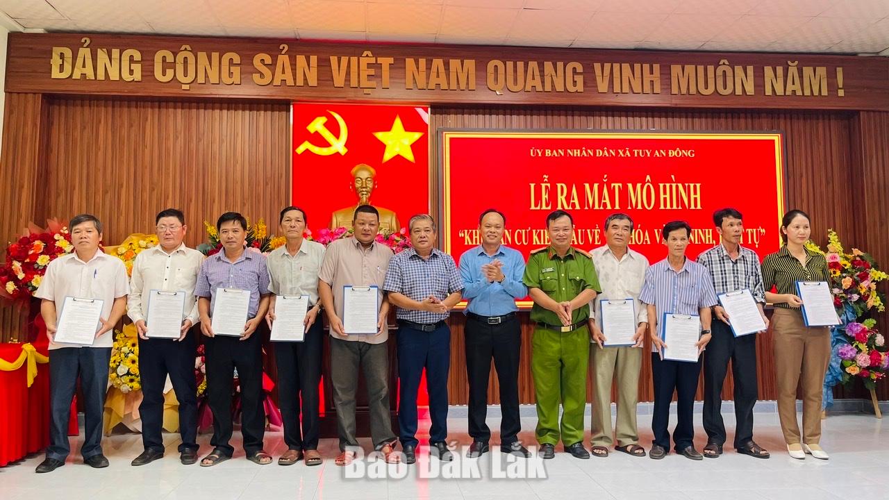 Lãnh đạo UBND xã và Công an xã Tuy An Đông trao quy chế thực hiện “Khu dân cư kiểu mẫu về văn hóa và an ninh, trật tự” cho các thôn.