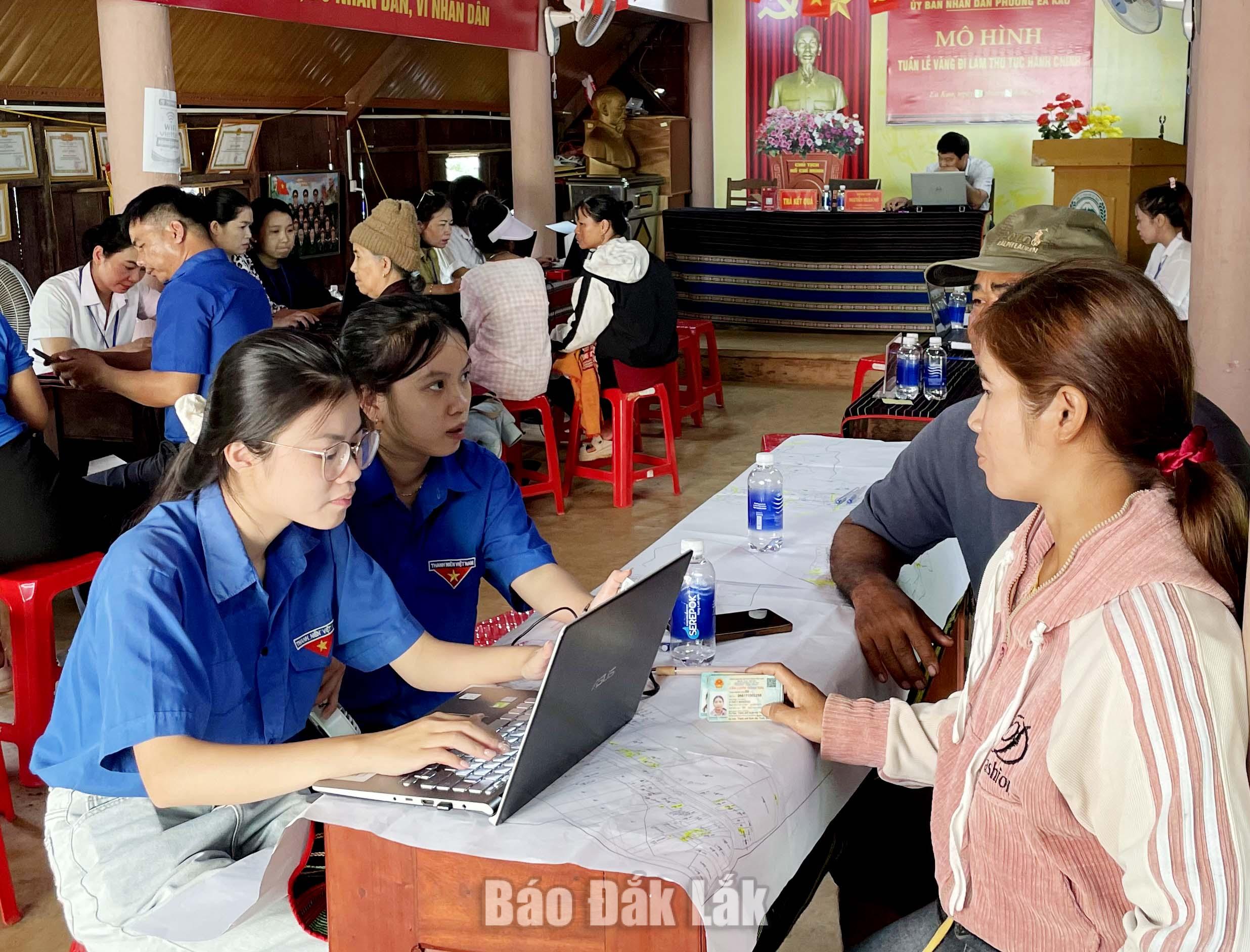 Các thành viên tổ công nghệ số cộng đồng phường Ea Kao hướng dẫn người dân thực hiện dịch vụ công trực tuyến, thanh toán không dùng tiền mặt. 
