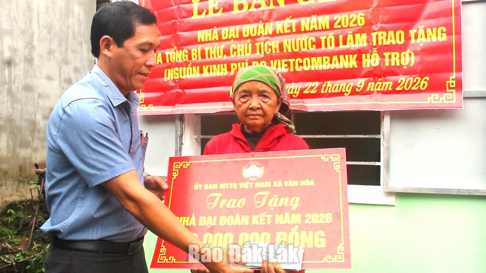 Anh Phan Trọng Khoan-Ủy viên Ban Thường vụ Đảng ủy, Chủ tịch Ủy ban Mặt trận Tổ quốc Việt Nam xã trao bảng biểu trưng tặng nahf cho bà Lê Mo Sơn.