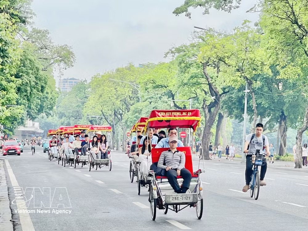 Foreigners tour Hanoi on cyclos (Photo: VNA)